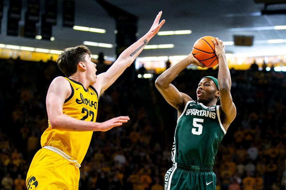 Michigan State guard Tre Holloman, right, shoots the ball as Iowa forward Patrick McCaffery defends during a NCAA Big Ten Conference men's basketball game, Saturday, Feb. 25, 2023, at Carver-Hawkeye Arena in Iowa City, Iowa.