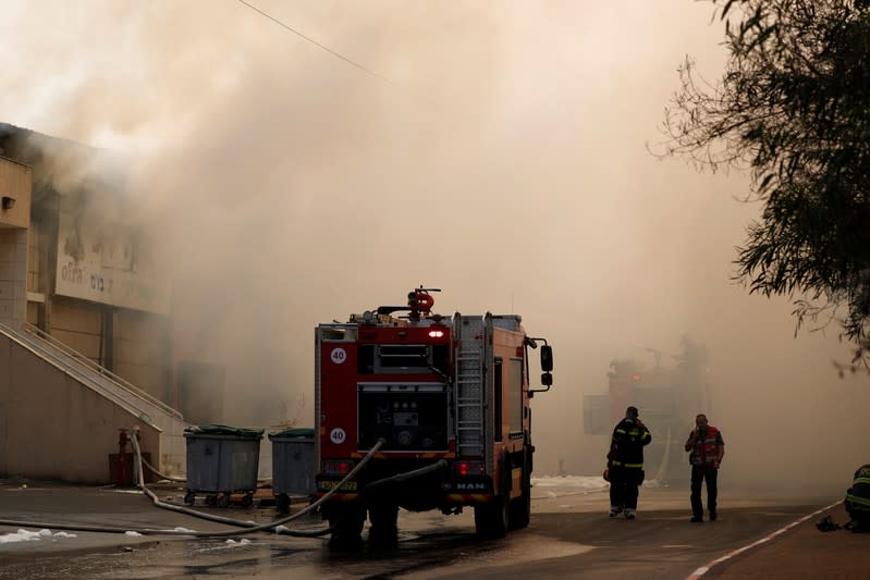 Israeli firefighters work to extinguish a fire in a factory in Sderot, southern Israel