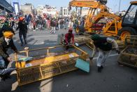 Farmers remove police barricades during a rally as they continue to protest against the central government's recent agricultural reforms in New Delhi on January 26, 2021. (Photo by Sajjad HUSSAIN / AFP) (Photo by SAJJAD HUSSAIN/AFP via Getty Images)