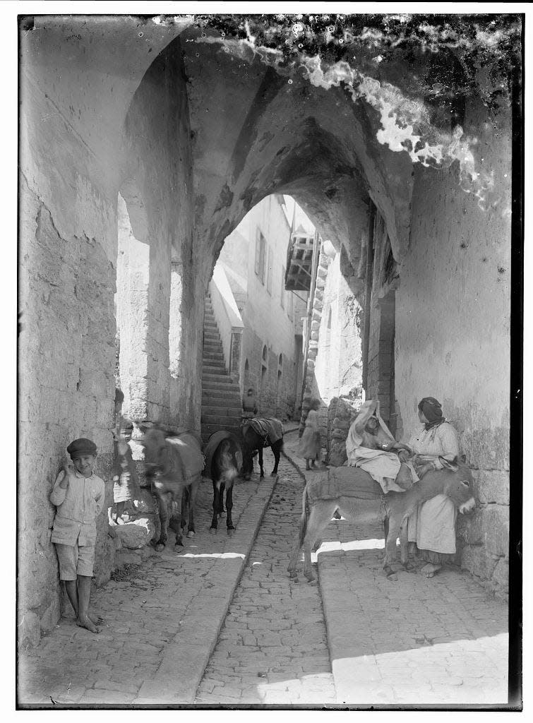 A black and white photo of an old city street in Nazareth.