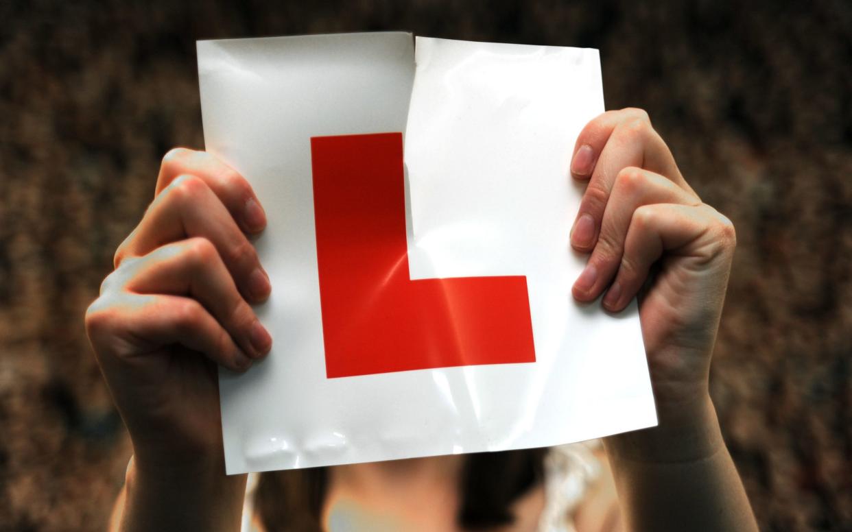 A person holding up a learning driver symbol