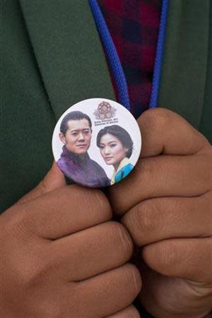 A school girl shows off a pin, with the images of King Jigme Khesar Namgyel Wangchuck and his fiancee Jetsun Pema, while taking part in a rehearsal ceremony ahead of the royal wedding in Bhutan's capital Thimphu on October 11, 2011. The Bhutanese king is scheduled to wed his fiancee Jetsun Pema over a three-day ceremony starting in the ancient capital Punakha on October 13. REUTERS/Adrees Latif