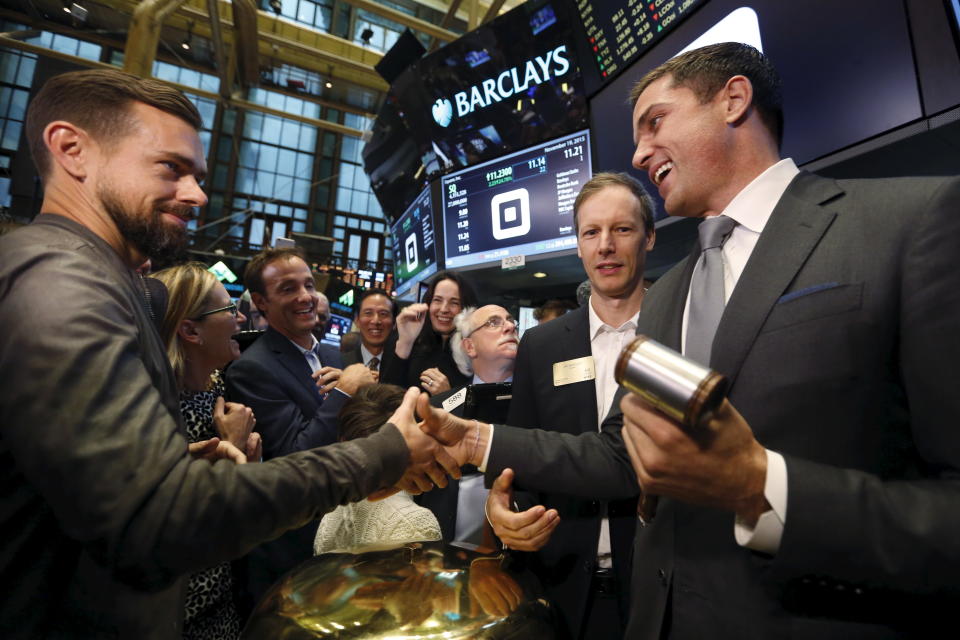 Jack Dorsey (L), CEO of Square and CEO of Twitter, is congratulated by Jim McKelvey, co-founder of Square, (2nd R) and NYSE President Tom Farley (R) after the IPO of Square Inc., in New York November 19, 2015. Square Inc priced shares at $9 for its initial public offering, about 25 percent less than it had hoped, as it struggled to win over investors skeptical about its business and valuation before trading begins on Thursday.  REUTERS/Lucas Jackson