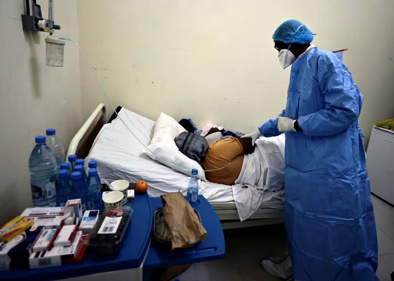 Professor Moussa Seydi, wearing his personal protective equipment (PPE) talks to a patient, who is suffering from the coronavirus disease (COVID-19) at the infectious diseases department of the University Hospital Fann, in Dakar