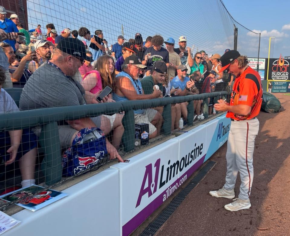 Orioles prospect Jackson Holliday taking signs autographs for fans before a game with the Double-A Bowie Baysox