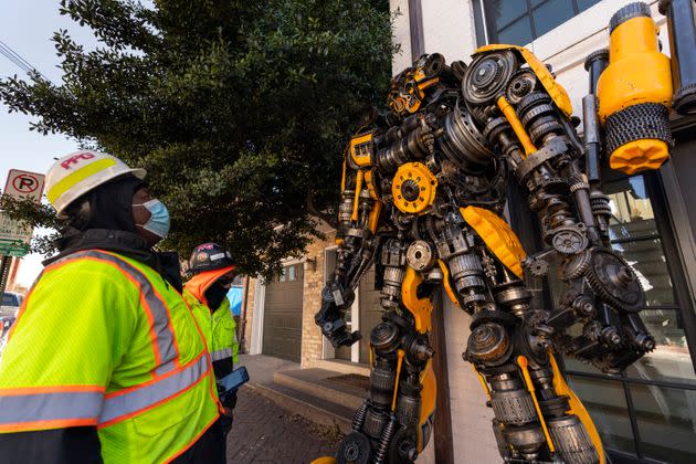Workers stop to admire and photograph Bumblebee outside the entrance of Howard's home in the Georgetown neighborhood in 2021.