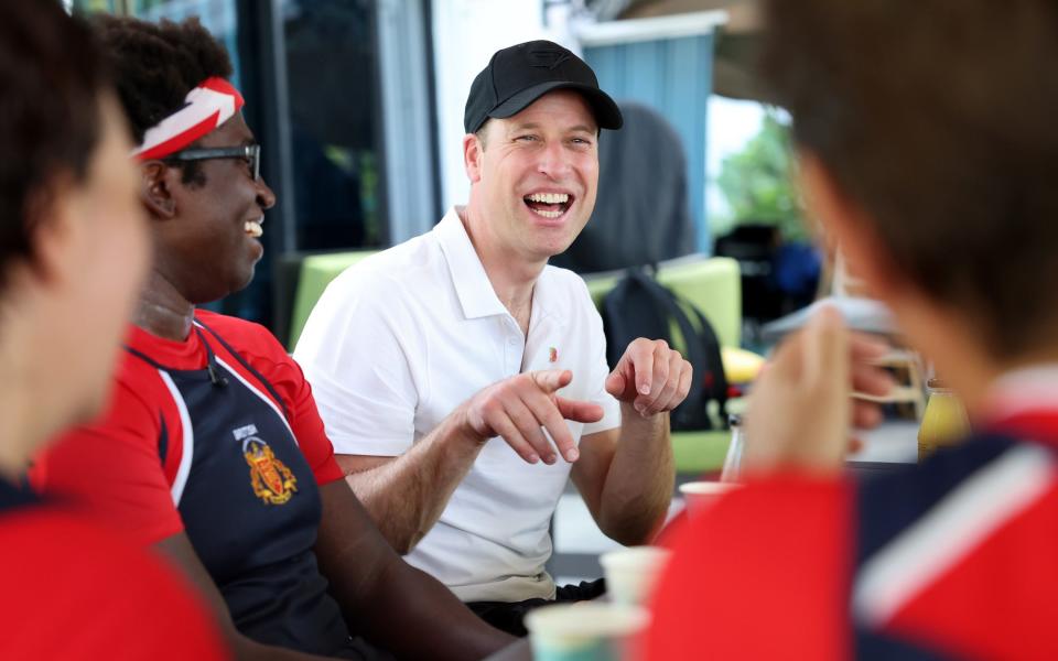 Prince William speaking to members of the British Dragons dragon boating club on day two of his visit to Singapore