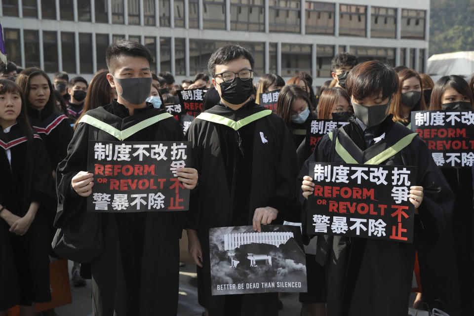 University students wearing masks, hold placards in protest against the government before their graduation ceremony at the Chinese University of Hong Kong, in Hong Kong, Thursday, Nov. 7, 2019. (AP Photo/Kin Cheung)