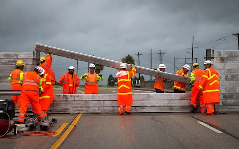 TxDOT crews install the final portion of a surge wall on TX-361 leading to the Port Aransas ferry in Aransas Pass, Texas, on Friday, Aug. 25, 2017 - Credit: Nick Wagner /Austin American-Statesman via AP