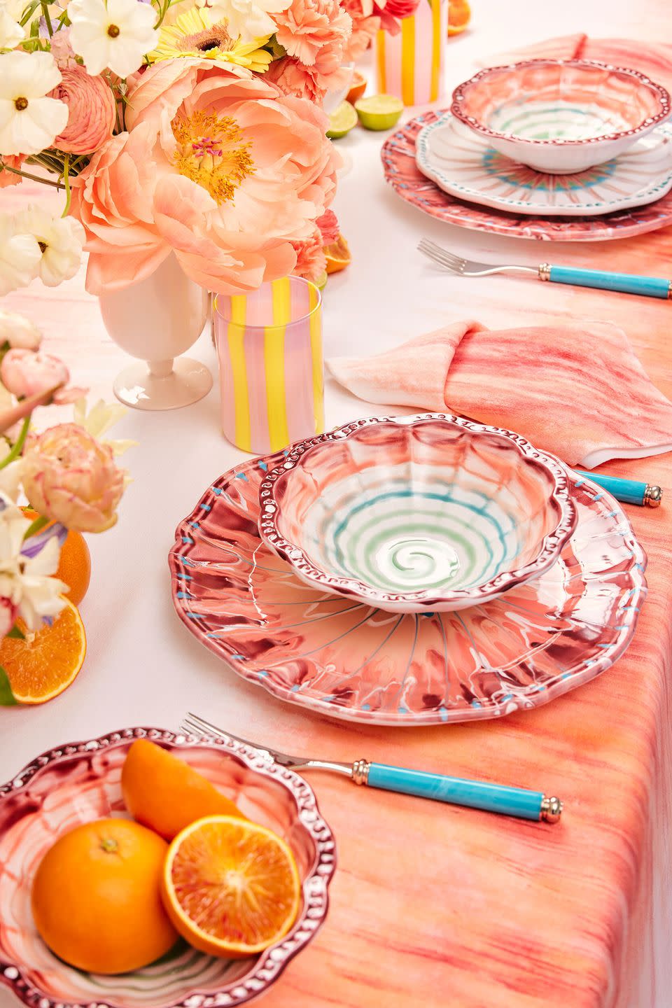 a table with plates and oranges