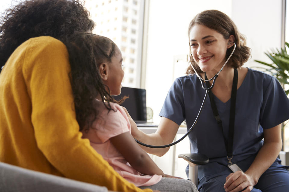 Nurse listening to child's heart with stethoscope