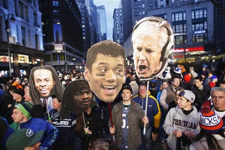 Fans hold up posters of (R-L) Seattle Seahawks head coach Pete Carroll, quarterback Russell Wilson, running back Marshawn Lynch, and cornerback Richard Sherman while they gather en masse at Super Bowl Boulevard fan zone ahead of Super Bowl XLVIII in New York February 1, 2014. REUTERS/Eduardo Munoz