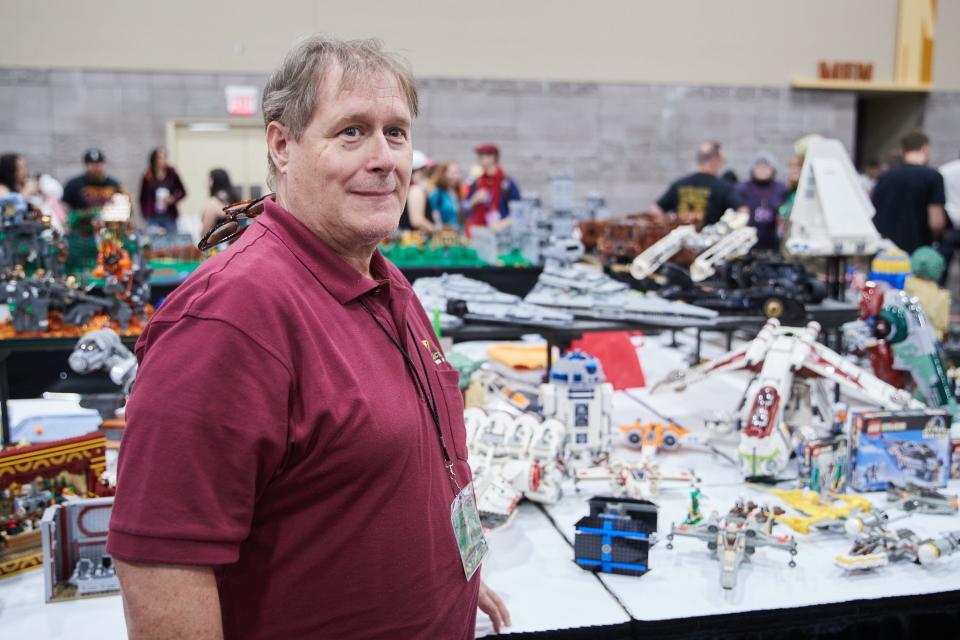 Russ Nicholson, a member of Cactus Brick, a Phoenix-based adult Lego group, poses for a photo near his Lego sets during Phoenix Fan Fusion at the Phoenix Convention Center.