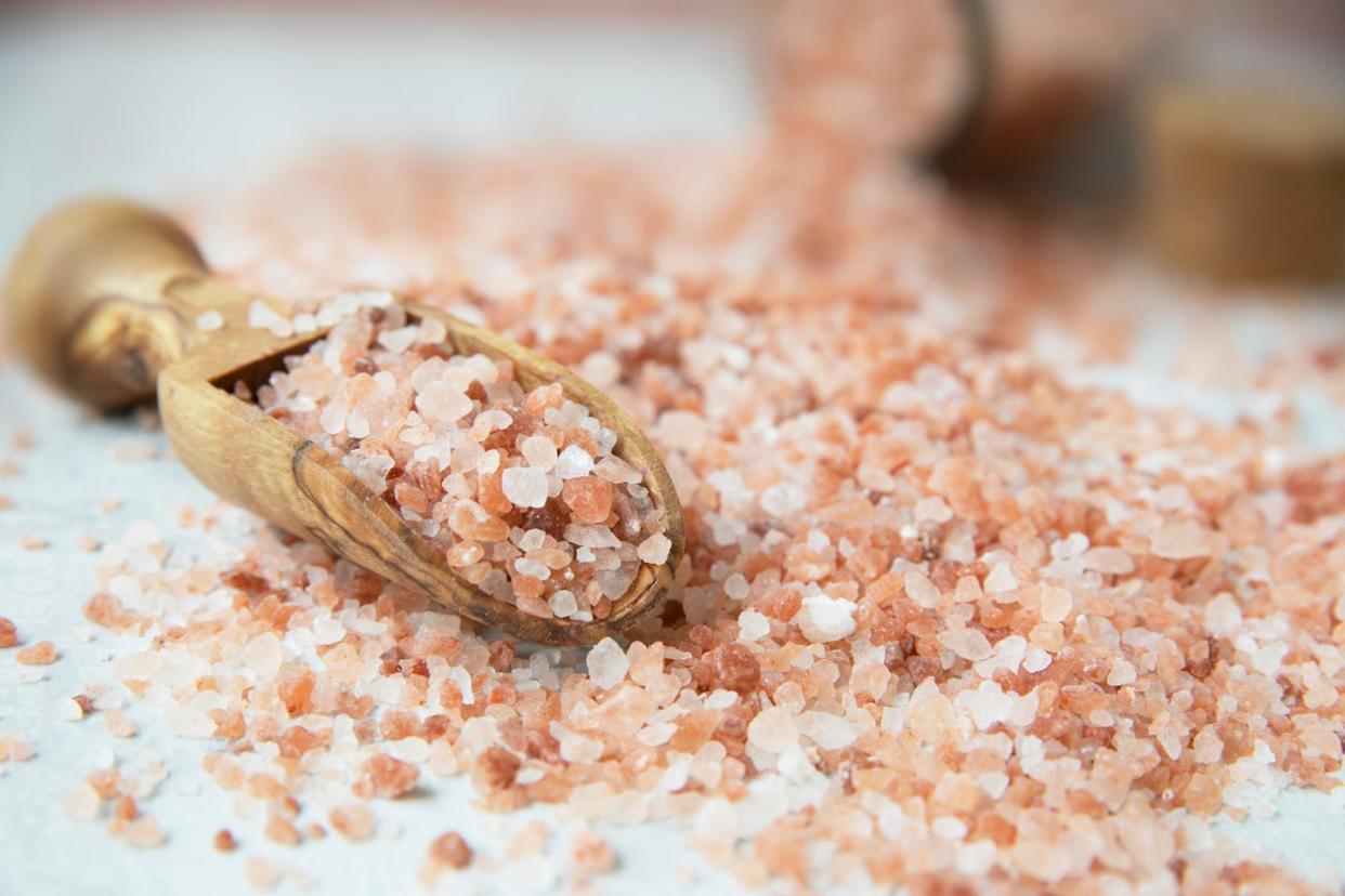 close up of salt in wooden spoon on table