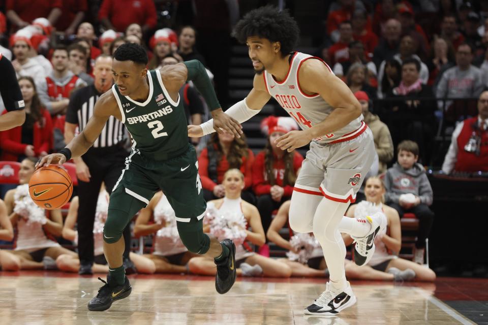 Michigan State's Tyson Walker, left, dribbles past Ohio State's Justice Sueing during the first half of an NCAA college basketball game on Sunday, Feb. 12, 2023, in Columbus, Ohio.