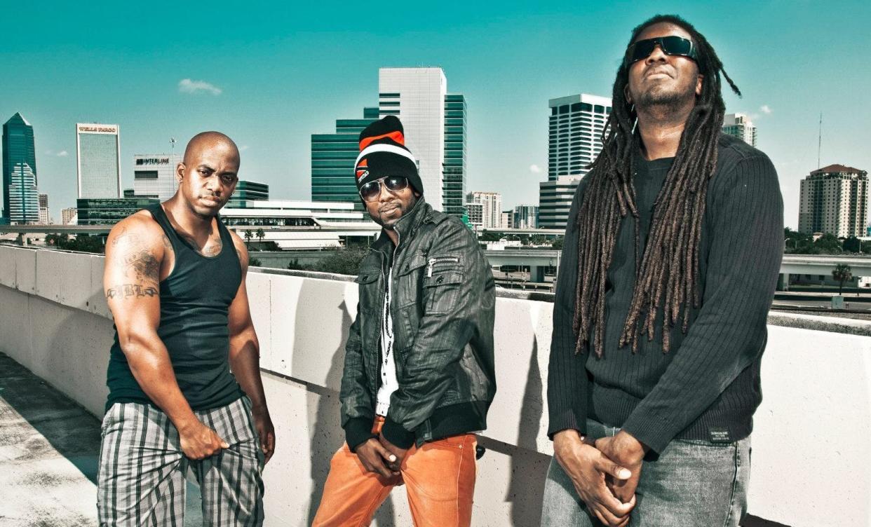 Jacksonville punk band Whole Wheat Bread stand in front of the city skyline.