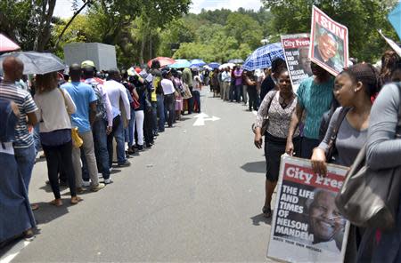 People wait for transport to take them to view the body of former South African President Nelson Mandela, who is lying in state, at the Union Buildings in Pretoria December 11, 2013. REUTERS/Mujahid Safodien