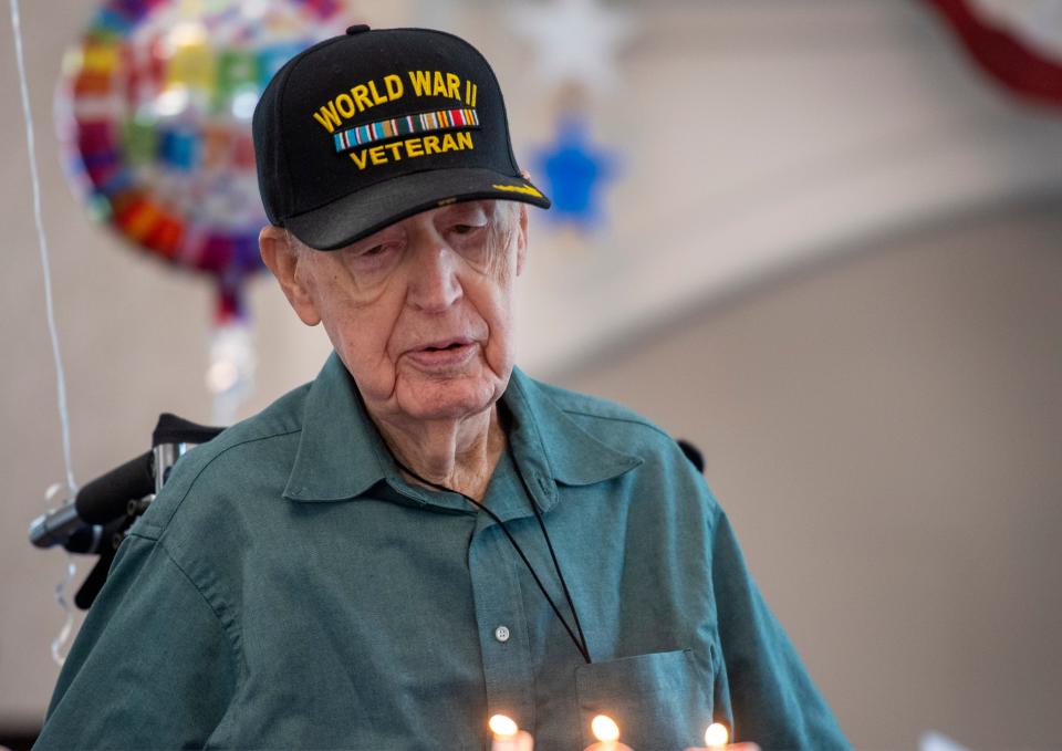 U.S. Army veteran Thurman Carnal stares down at his cake while friends and family sing “Happy Birthday” during a celebration for his 107th birthday at the Terrace at Solarbron in Evansville, Ind., Thursday, July 6, 2023.