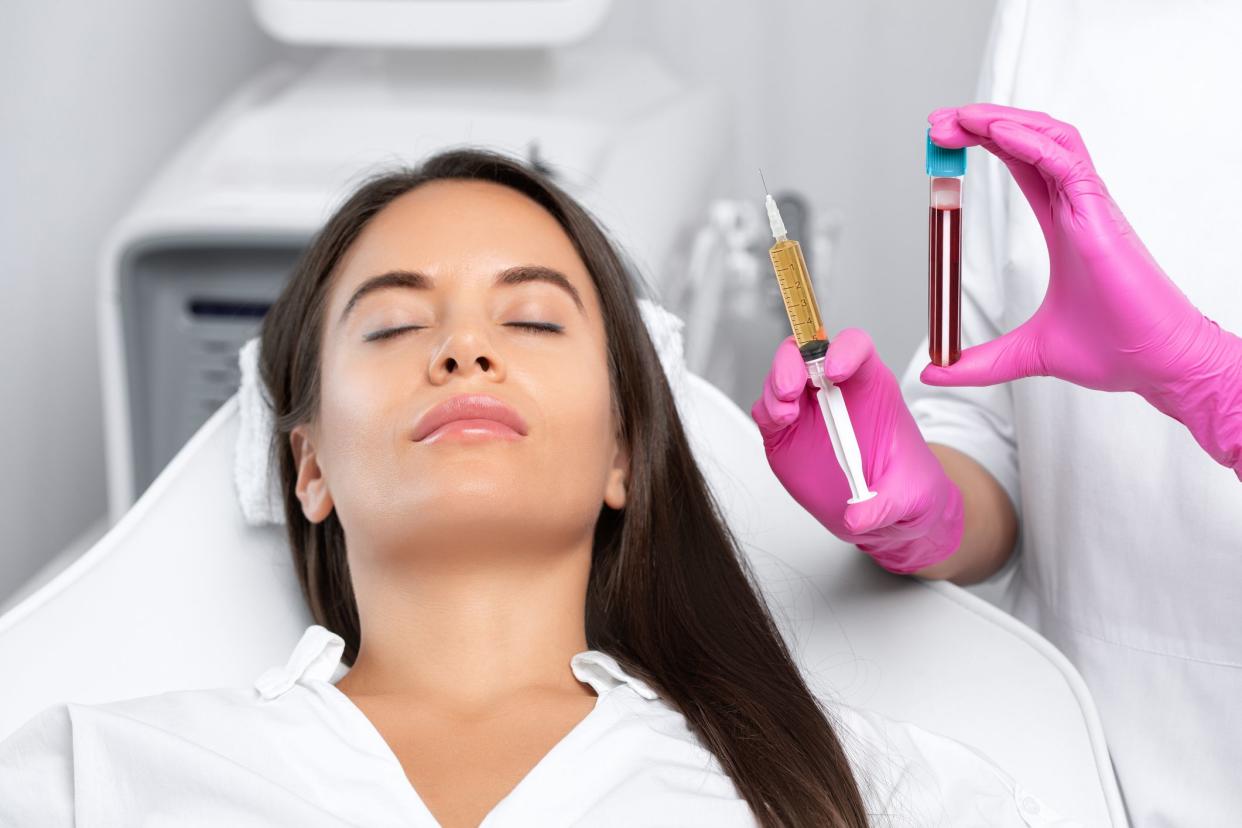 Beautician will do PRP therapy for the face against wrinklesand against hair loss of a beautiful woman in beauty salon.Doctor holds test tubes with venous blood and blood plasma.Cosmetology concept.