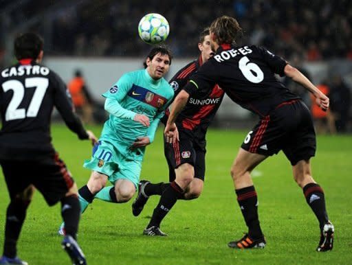 Leverkusen's midfielder Simon Rolfes (R) and Barcelona's Argentinian striker Lionel Messi (C) vie for the ball during the UEFA Champions League round of sixteen first leg match Bayer Leverkusen vs FC Barcelona at BayArena in Leverkusen, western Germany. Barca took a giant step towards the Champions League's quarter-finals with a 3-1 win at Bayer Leverkusen