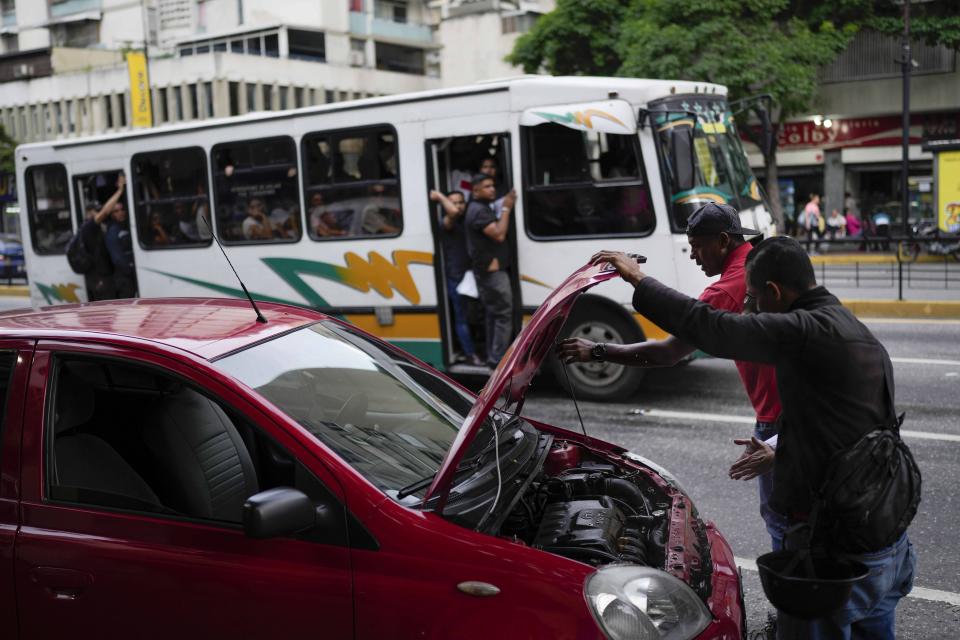 FILE - Motorists stop cool down their overheating car in Caracas, Venezuela, Oct. 3, 2023. (AP Photo/Matias Delacroix, File)