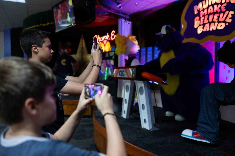 Oliver Zepsa, 14, back, and his brother, Dominic, 12, take photos of Munch’s Make Believe Band at Chuck E. Cheese in Charlotte, N.C., on Friday, May 31, 2024. Oliver and Dominic are animatronics enthusiasts and came to see the animatronics once they heard the news that this location would be one of the five being saved in the U.S.