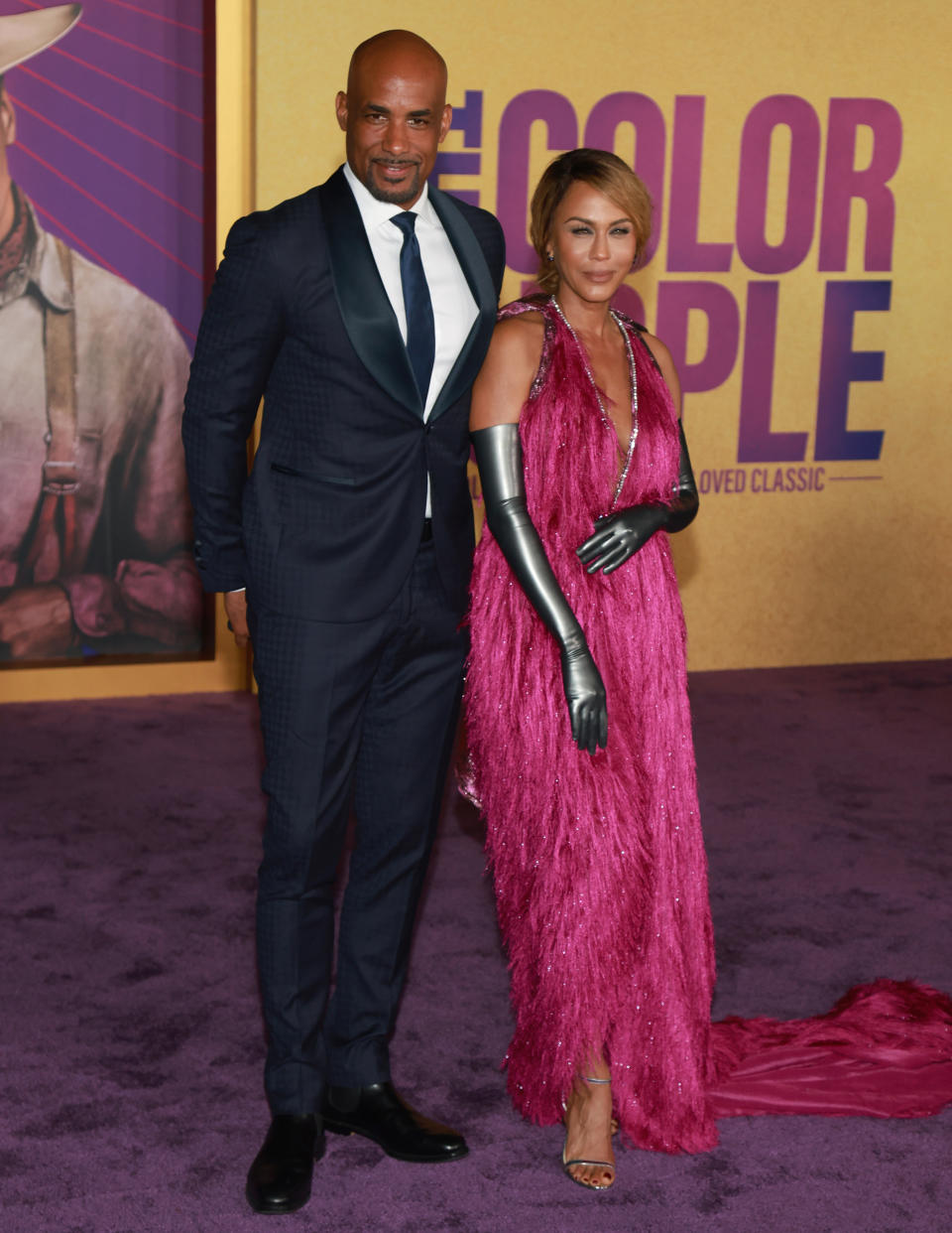 Boris in a black suit and tie and Nicole in a feathery sleeveless, halter-top pinkish gown