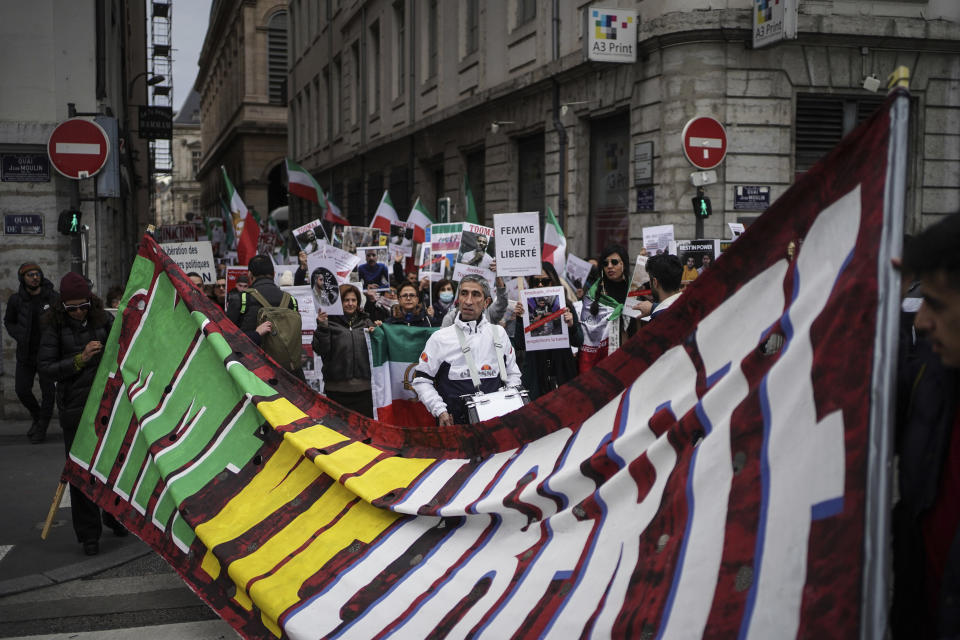 People demonstrate in Lyon, central France, Sunday, Jan. 8, 2023. Hundreds of people marched Sunday in France to honor an Iranian Kurdish man who took his own life in a desperate act of anguish over the nationwide protests in Iran. Police estimated the size of the crowd that gathered for Mohammad Moradi at about 1,000 people. They marched in the city of Lyon, where the 38-year-old Moradi took his own life in December, drowning in the Rhone river. (AP Photo/Laurent Cipriani)