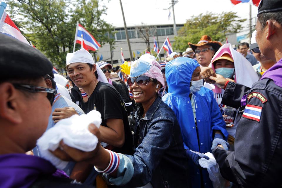 Policemen and anti-government protesters great each other inside the compound of metropolitan police headquarters, the site of fierce clashes over the last few days, in Bangkok December 3, 2013. Thailand's government ordered police to stand down and allow protesters into state buildings on Tuesday, removing a flashpoint for clashes and effectively bringing an end to days of violence in Bangkok in which five people have died. REUTERS/Damir Sagolj (THAILAND - Tags: CIVIL UNREST POLITICS CRIME LAW)