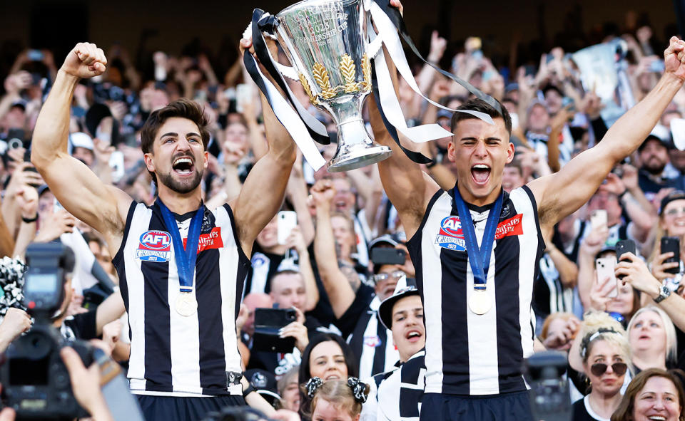 Josh and Nick Daicos, pictured here with the premiership cup after Collingwood's victory.