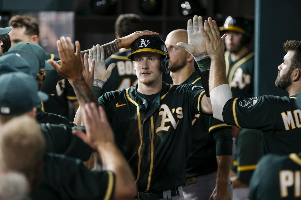 Oakland Athletics' Sean Murphy (12) is congratulated by teammates after hitting a solo home run during the seventh inning of a baseball game against the Texas Rangers, Wednesday, June 23, 2021, in Arlington, Texas. (AP Photo/Brandon Wade)