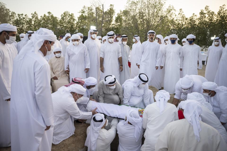 This photo made available by the Ministry of Presidential Affairs, shows Sheikh Mohamed bin Zayed Al Nahyan, Ruler of Abu Dhabi, center left, with others, attends the burial of Sheikh Khalifa bin Zayed Al Nahyan, President of the United Arab Emirates, with other members of royal family at Al Bateen cemetery, in Abu Dhabi, Friday, May 13, 2022. (Ministry of Presidential Affairs via AP/Abdulla Al Junaibi)