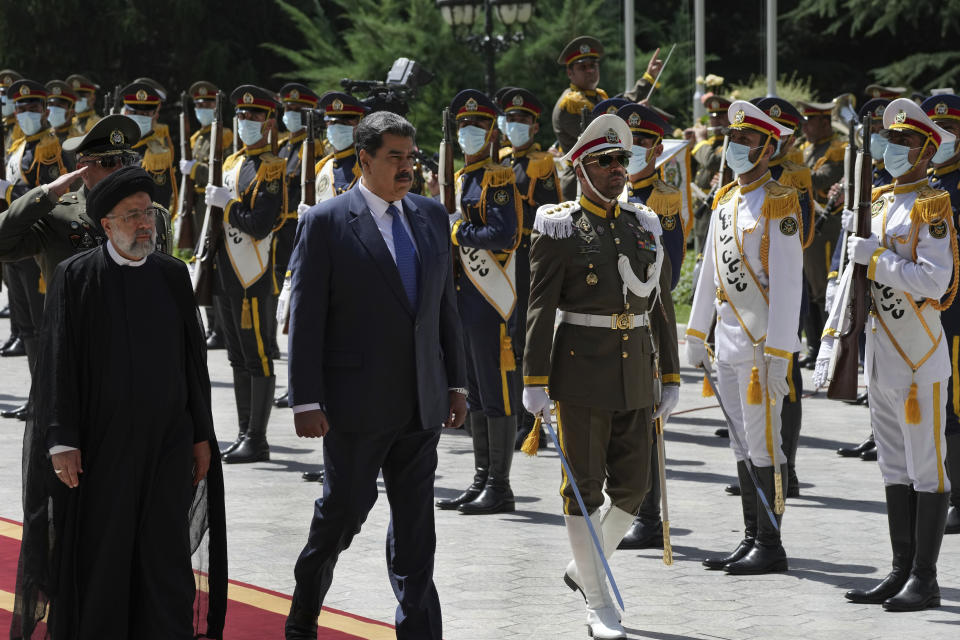 Venezuela's President Nicolas Maduro, second left, reviews an honor guard as he is accompanied by his Iranian counterpart Ebrahim Raisi, left, during his official welcoming ceremony at the Saadabad Palace in Tehran, Iran, Saturday, June 11, 2022. (AP Photo/Vahid Salemi)