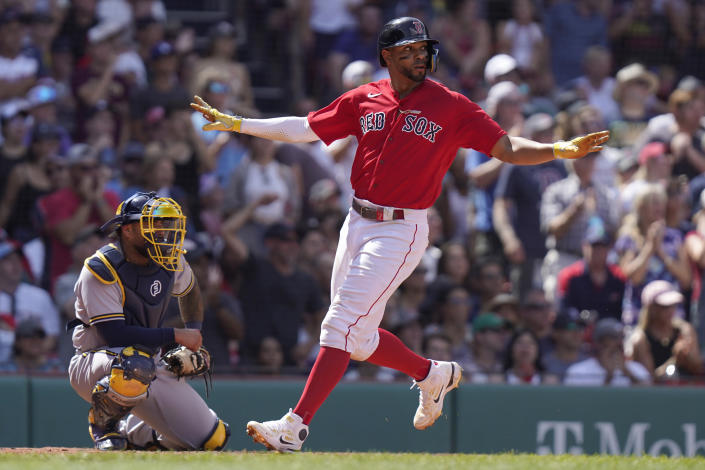 Boston Red Sox's Xander Bogaerts, right, scores on a double by J.D. Martinez as Milwaukee Brewers' Omar Narvaez, left, looks on in the fifth inning of a baseball game, Sunday, July 31, 2022, in Boston. (AP Photo/Steven Senne)