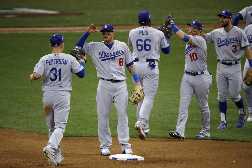 Los Angeles Dodgers players celebrate after Game 2 of the National League Championship Series baseball game against the Milwaukee Brewers Saturday, Oct. 13, 2018, in Milwaukee. The Dodgers won 4-3. (AP Photo/Charlie Riedel)