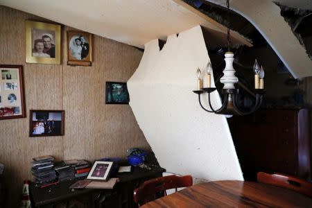 Family photos hang on the wall of a dining room damaged by Hurricane Michael in Fountain, Florida, U.S., October 15, 2018. REUTERS/Terray Sylvester