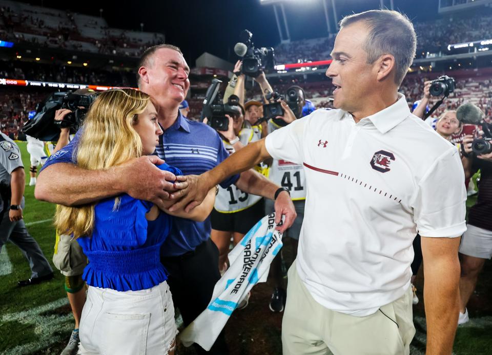 Sep 3, 2022; Columbia, South Carolina, USA; Georgia State Panthers head coach Shawn Elliott gets a hug from his daughter Maddyn Elliott as he speaks with South Carolina Gamecocks head coach Shane Beamer following their game at Williams-Brice Stadium. Mandatory Credit: Jeff Blake-USA TODAY Sports