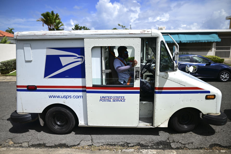 Postal worker Rawy Perez gets in his truck to start his rounds in Carolina, Puerto Rico, Wednesday, Sept. 30, 2020. The absence of street names and numbers across the island has long been a problem for the U.S. territory, where internet map services sometimes fail. (AP Photo/Carlos Giusti)