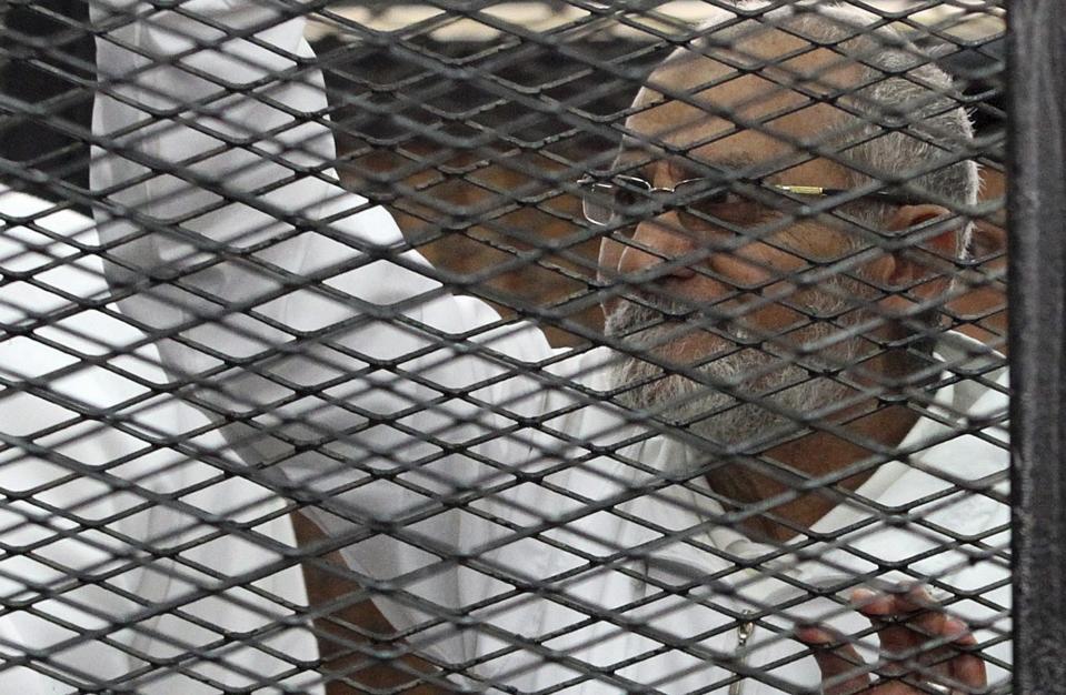 Muslim Brotherhood leader Mohammed Badie looks on from the defendant's cage during his trial with other leaders of the group in a courtroom in Cairo