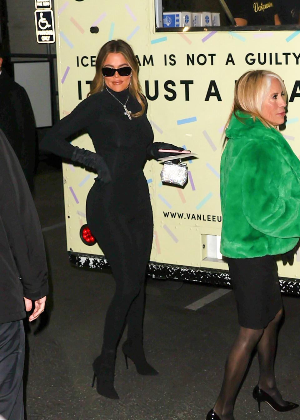 Khloe Kardashian in an all-black catsuit and black gloves