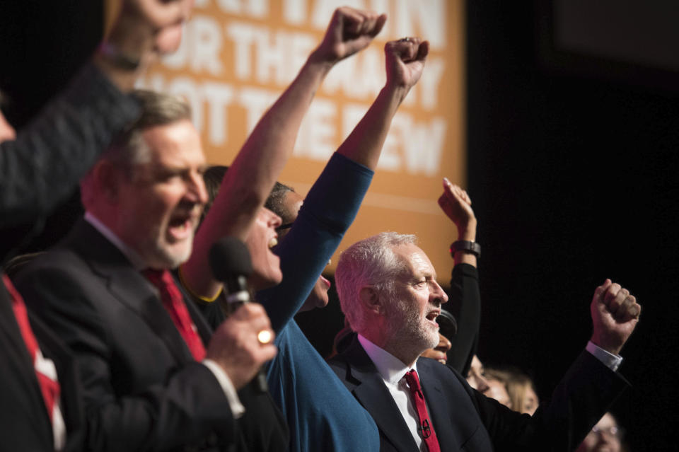 Britain's main opposition Labour Party leader Jeremy Corbyn, right, is joined on stage by supporters following his keynote speech, to sing the socialist song The Red Flag, at the annual party conference in Liverpool, England, Wednesday Sept. 26, 2018. Corbyn rallied his Labour Party on Wednesday, calling for a clampdown on unfettered capitalism and a huge investment in public services as he tried to refocus attention on domestic policies after an annual conference dominated by Brexit. (Peter Byrne/PA via AP)