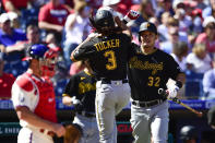 Pittsburgh Pirates' Cole Tucker (3) celebrates with Yoshi Tsutsugo, right, after hitting a solo home run off Philadelphia Phillies staring pitcher Hans Crouse during the first inning of a baseball game, Sunday, Sept. 26, 2021, in Philadelphia. (AP Photo/Derik Hamilton)