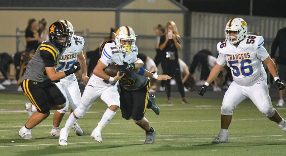 Agoura quarterback Harrison Novak tries to break free of a Newbury Park defender during their Canyon League game on Oct. 6.