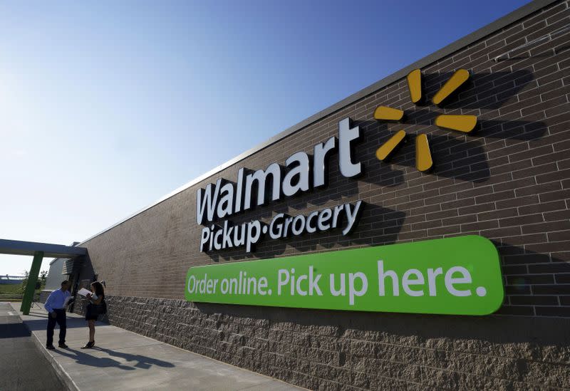 FILE PHOTO: People talk outside a Wal-Mart Pickup-Grocery test store in Bentonville