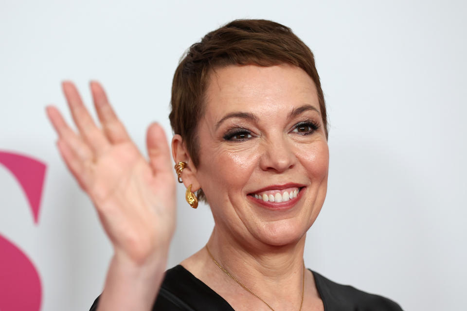 Olivia Colman smiling and waving at the camera