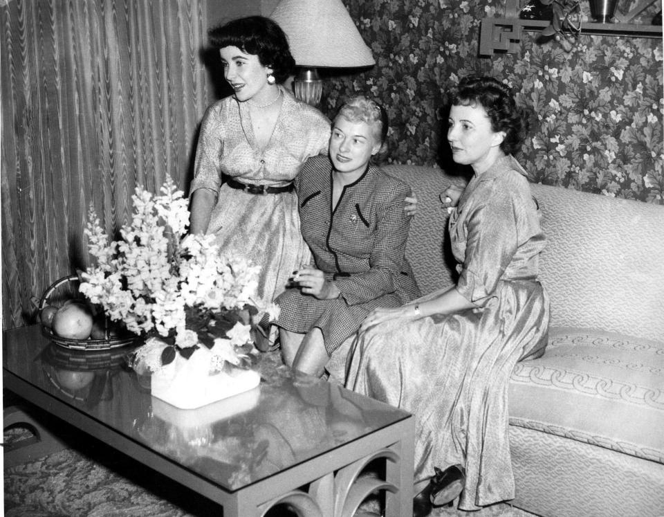 March 29, 1950 - BRIDE-ELECT OF EL PASOAN: Miss Elizabeth Taylor, left, is shown with Mrs. Mack Saxon, center, mother of Miss Taylor's fiance, Conrad N. Hilton Jr., of El Paso and her mother, Mrs. Francis Taylor. They are pictured in Miss Taylor's suite in the Hilton hotel here, as they chatted about the couple's wedding plans.