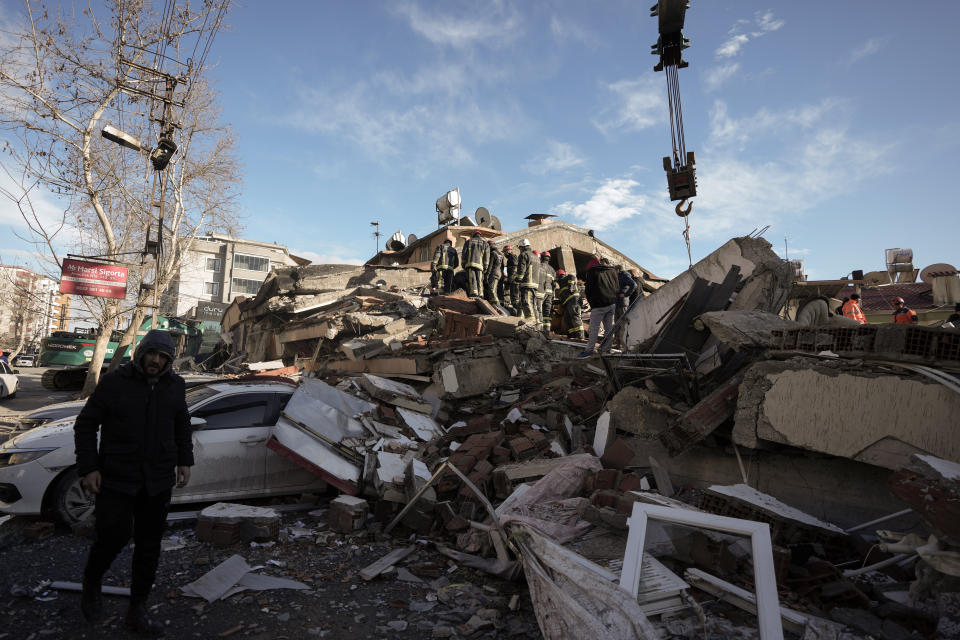 Rescue teams search in the rubble of a destroyed building in Kahramanmaras, southern Turkey, Tuesday, Feb. 7, 2023. A powerful earthquake hit southeast Turkey and Syria early Monday, toppling hundreds of buildings and killing and injuring thousands of people. (AP Photo/Khalil Hamra)