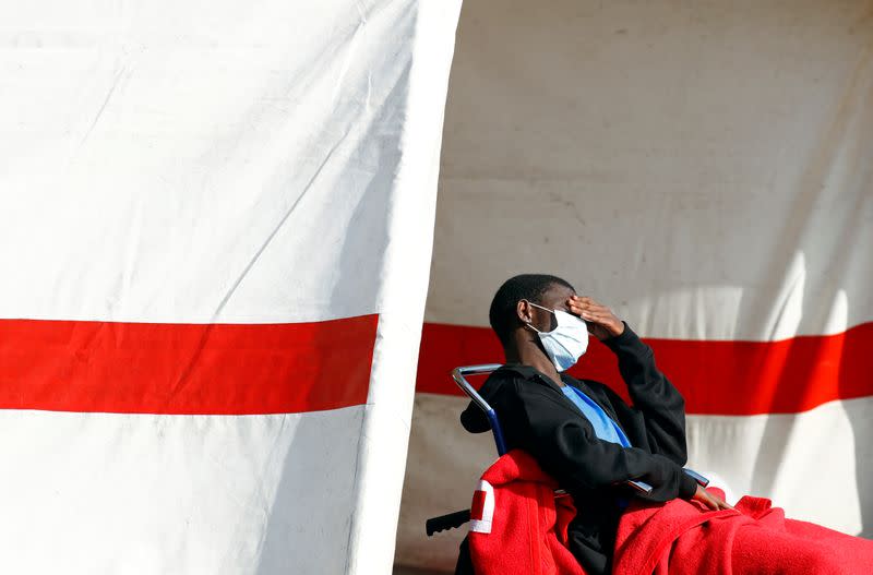 Migrant rescued in the Atlantic Ocean rests in a tent waiting to be transferred by the police, in the port of Arguineguin on the island of Gran Canaria