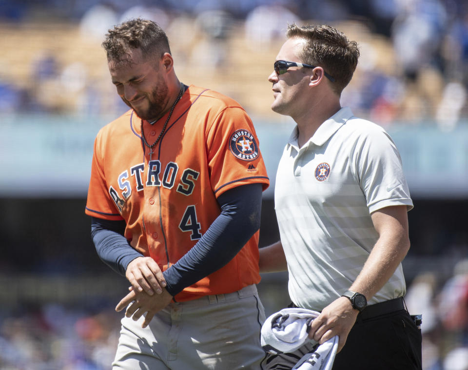 Houston Astros' George Springer, left, exits with a trainer after getting injured whiletrying to steal second base during the third inning of a baseball game against the Los Angeles Dodgers in Los Angeles, Sunday, Aug. 5, 2018. (AP Photo/Kyusung Gong)