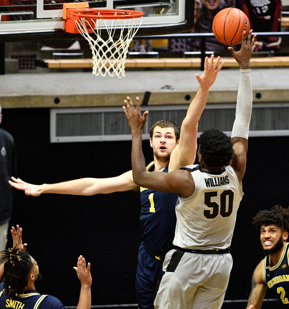 Michigan center Hunter Dickinson defends the shot by Purdue forward Trevion Williams during the second half at Mackey Arena in West Lafayette, Ind., Friday, Jan. 22, 2021.